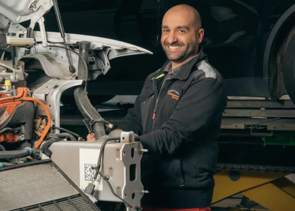 Carrossier devant une Tesla démontée en réparation – Carrosserie Tropea à Chambéry