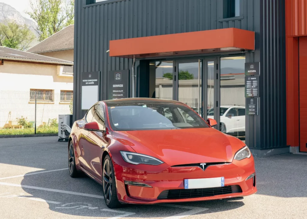 Tesla rouge stationnée devant l'atelier – Carrosserie Tropea à Chambéry