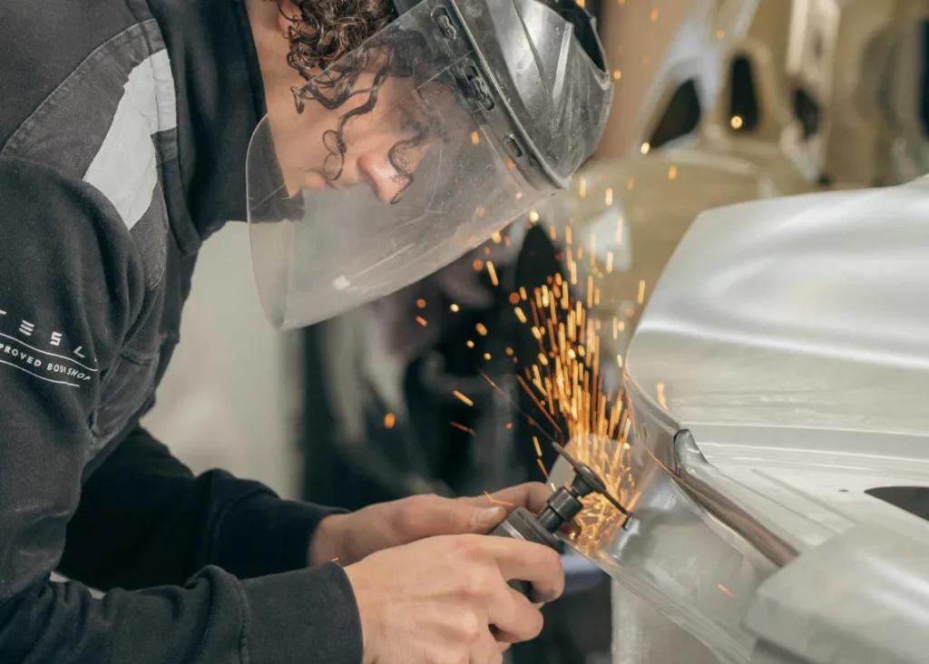 Travaux de tôlerie et meulage sur une pièce de carrosserie – Carrosserie Tropea à Chambéry