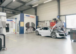 Cabine de peinture et Tesla blanche dans l'atelier – Carrosserie Tropea à Chambéry